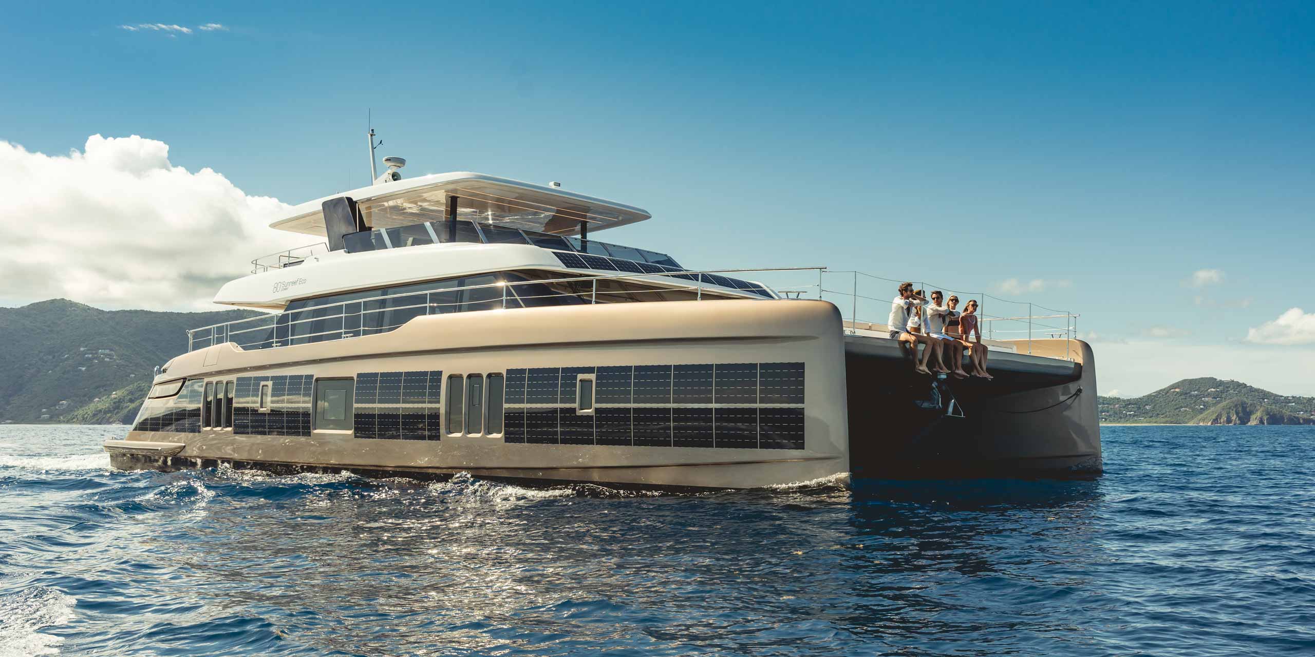 A group enjoying a yacht charter on the bow of SOL